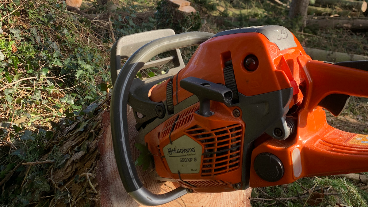 Husqvarna chainsaw resting on a freshly cut log